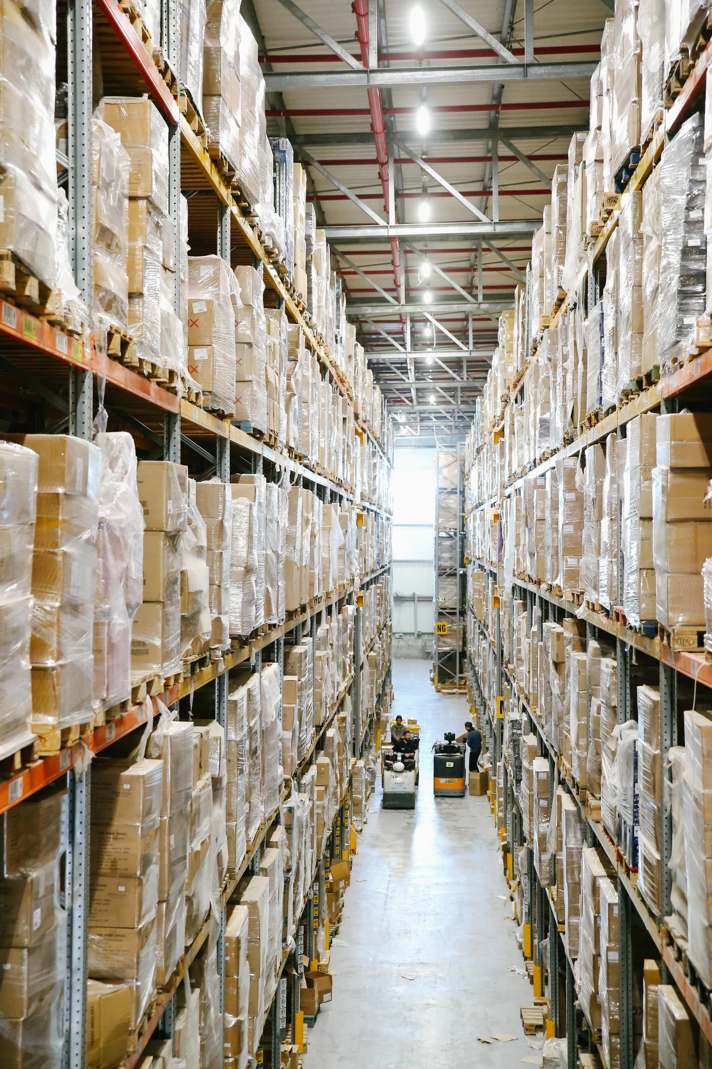 A warehouse aisle lined with shelves of packaged stock